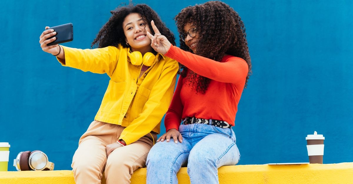 Duas mulheres tirando selfie para postar representando collab Instagram