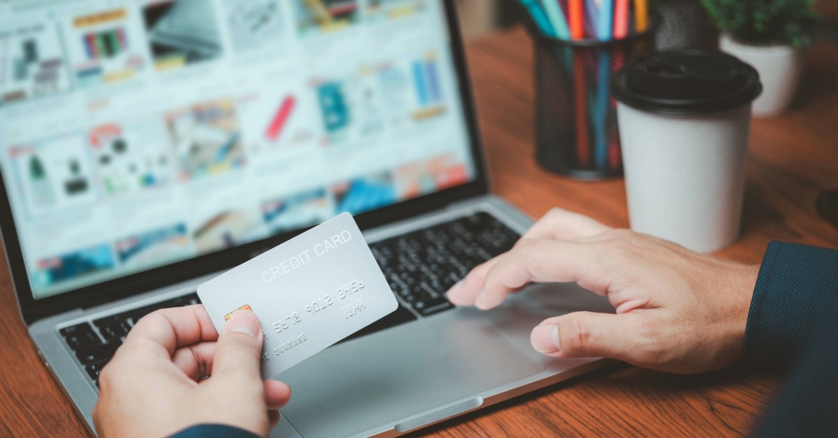 Cliente comprando em loja virtual com cartão de crédito no notebook, representando mensagens de carrinho abandonado para recuperação de vendas